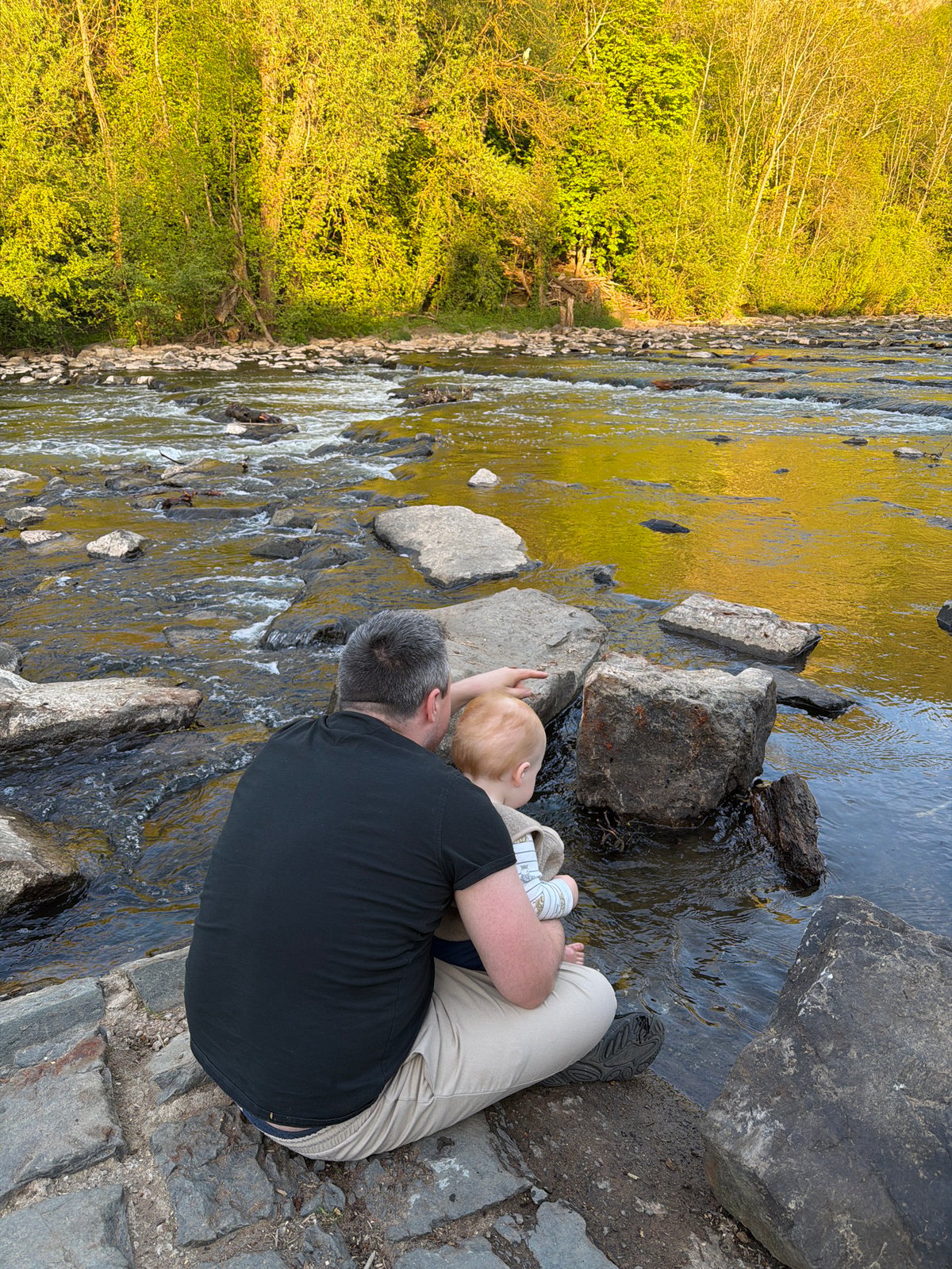 Parent and baby enjoy riverside moment in Meisenheim, Germany