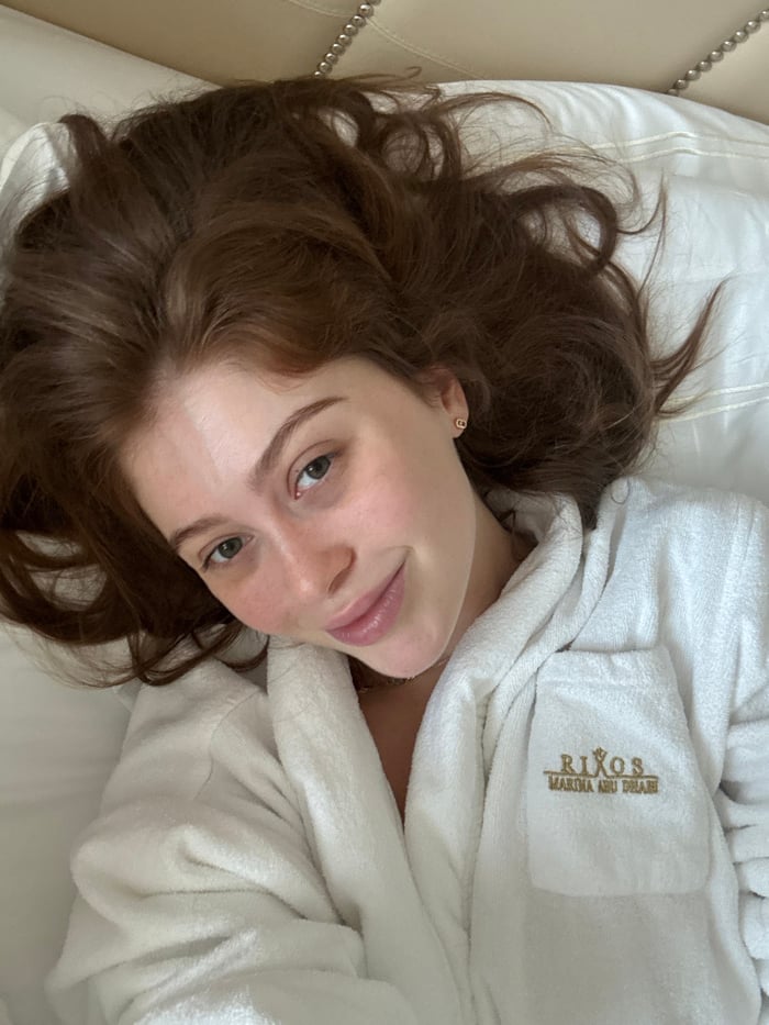 Woman in hotel robe rests in Abu Dhabi marina accommodation