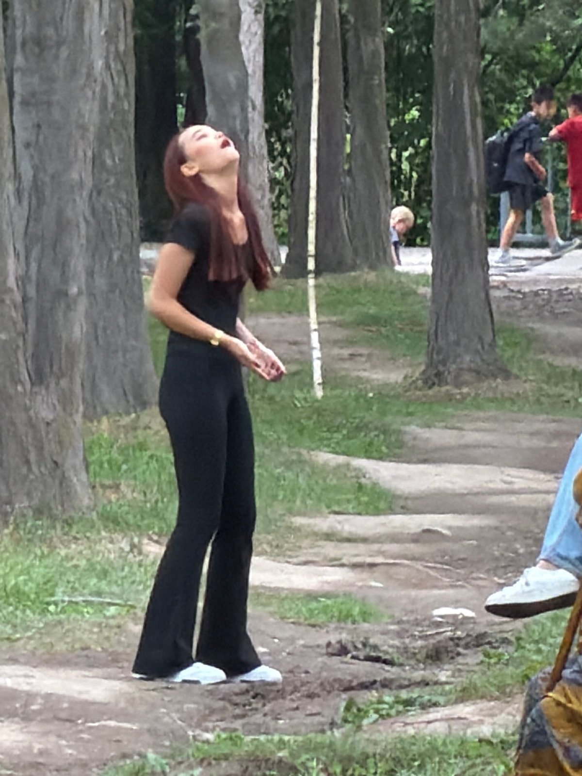 Casual park morning: walks, benches, badminton, and passing traffic.