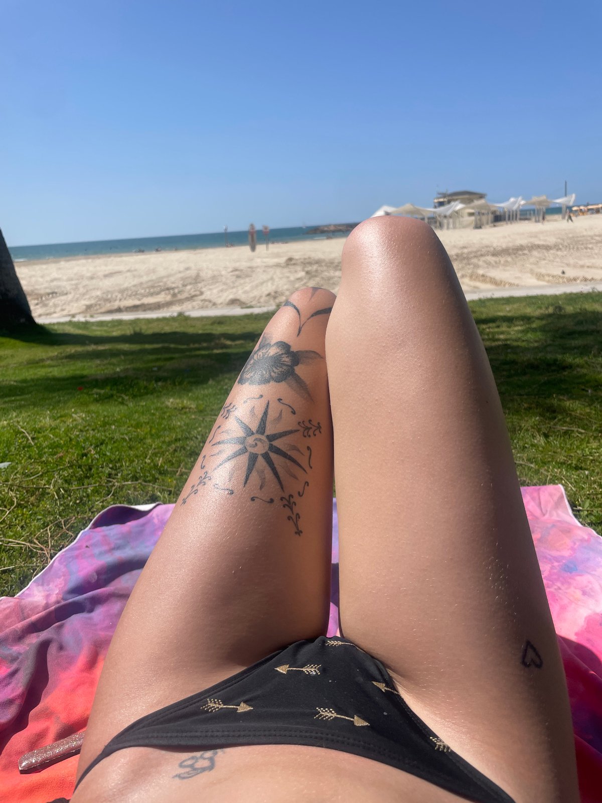 Woman sunbathes on blanket near Herzliya beach