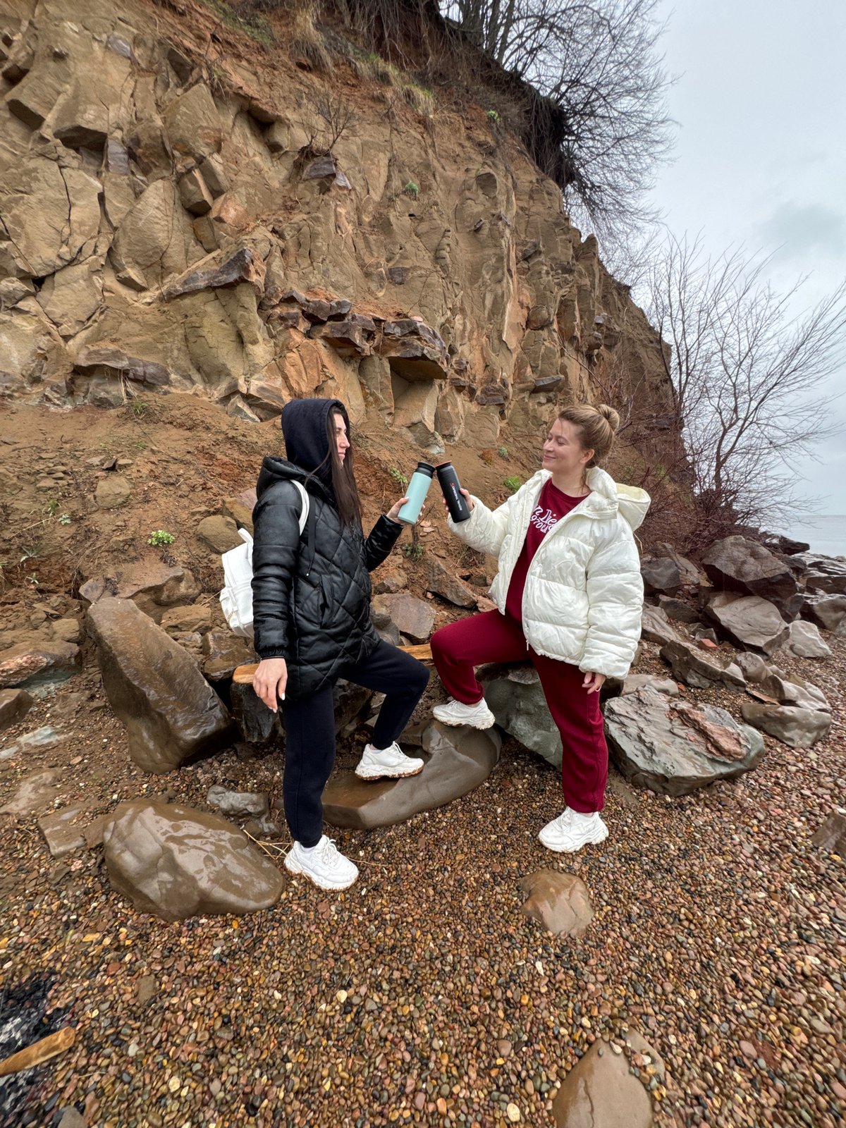 Two women explore pebble beach in Kostovaty, Russia
