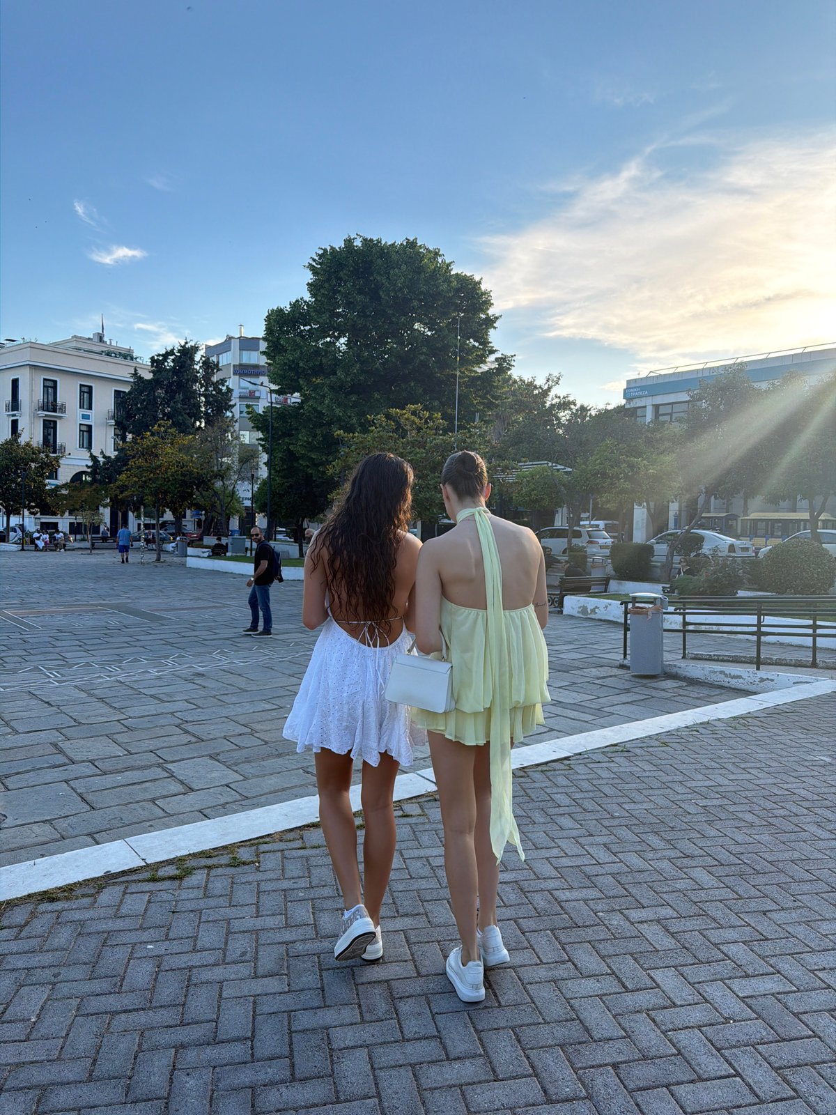 Two women in summer dresses stroll through historic Kavala