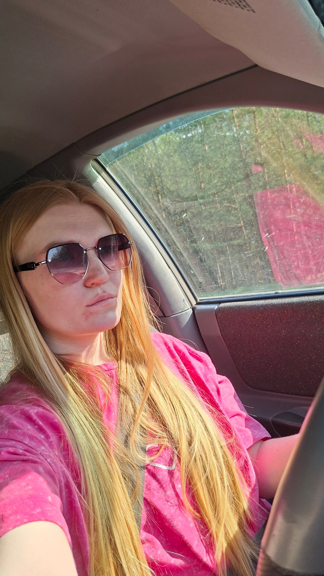 Person in pink shirt resting inside vehicle in Chaikovsky