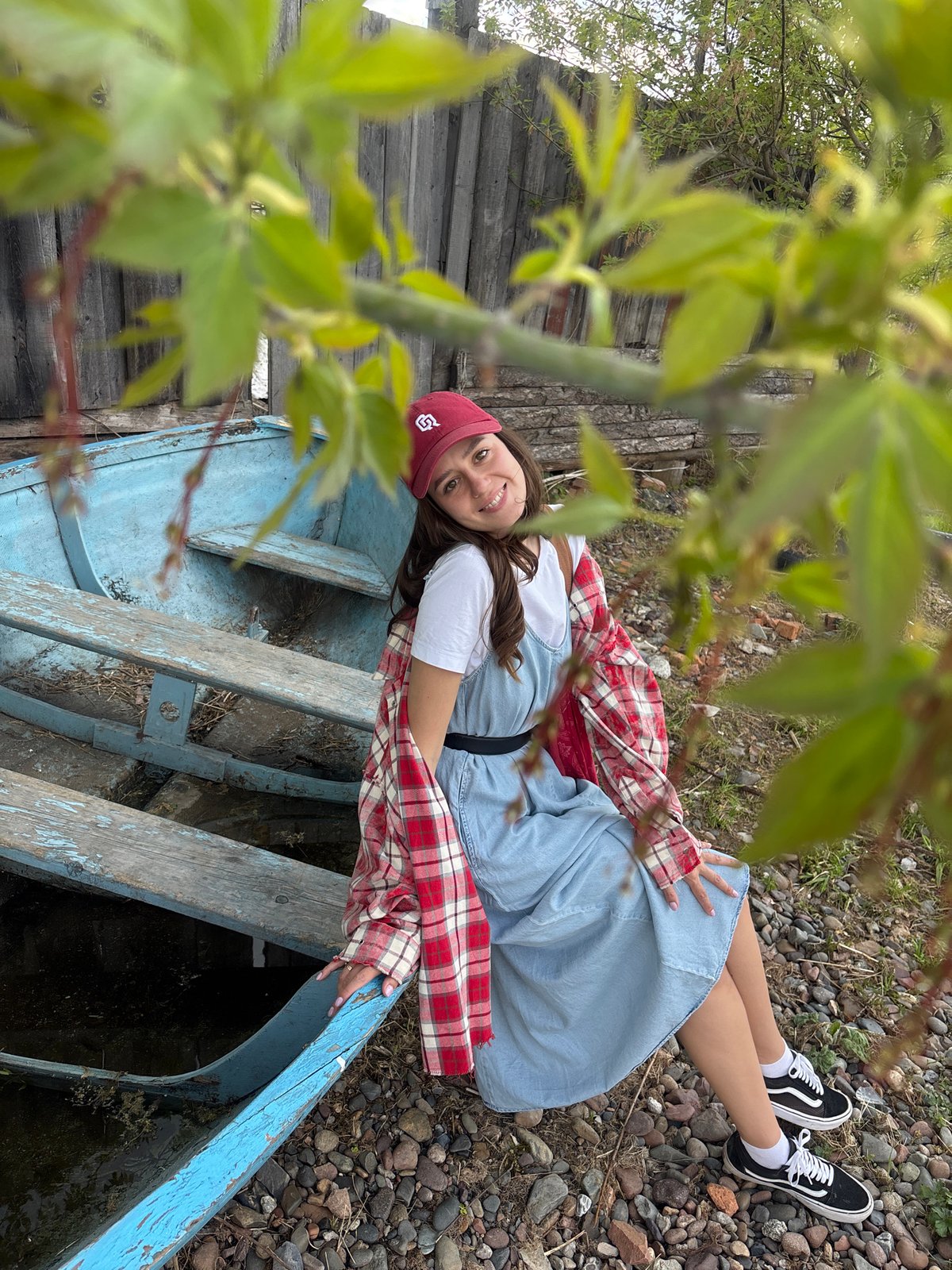 Woman relaxes in boat by rural Russian waterfront