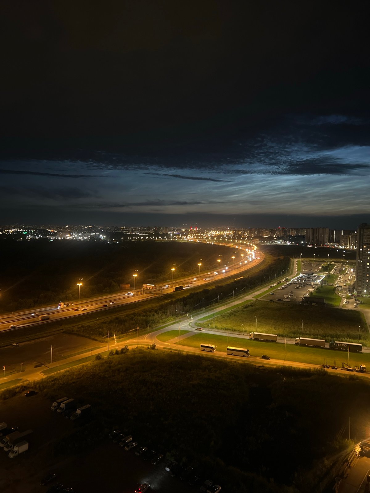 Nighttime aerial views of a city grid and highway interchange.
