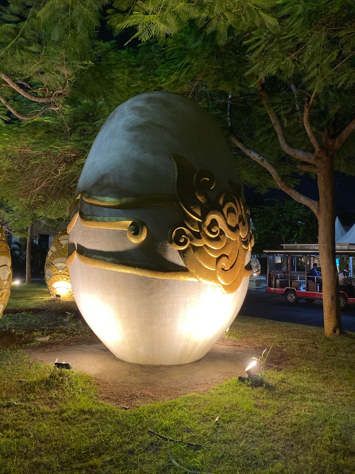 Nighttime resort grounds in Kuta Selatan with ornate egg sculptures and trolleys