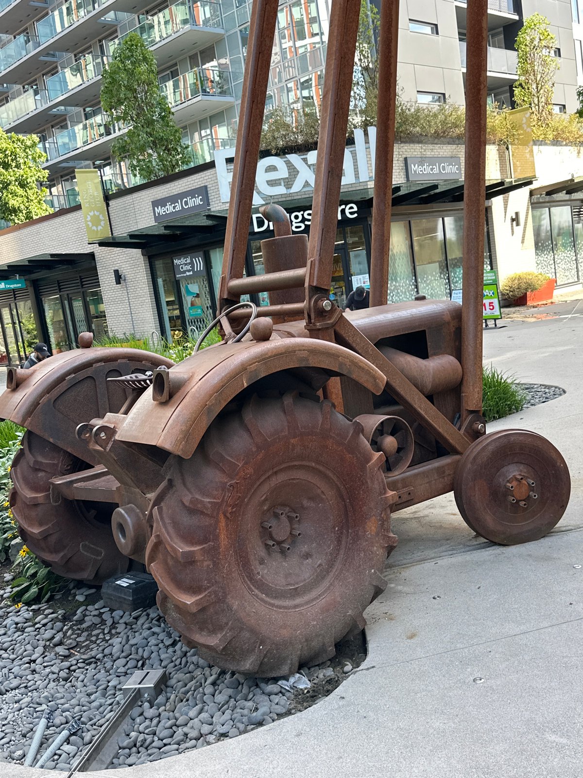 Rusty tractor sculpture and urban architecture in Surrey, BC