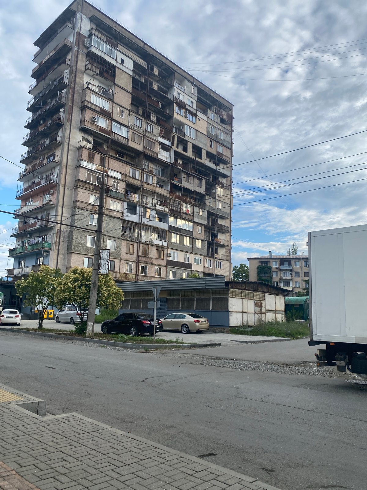 Quiet urban block, cloudy morning, apartment complex and street life