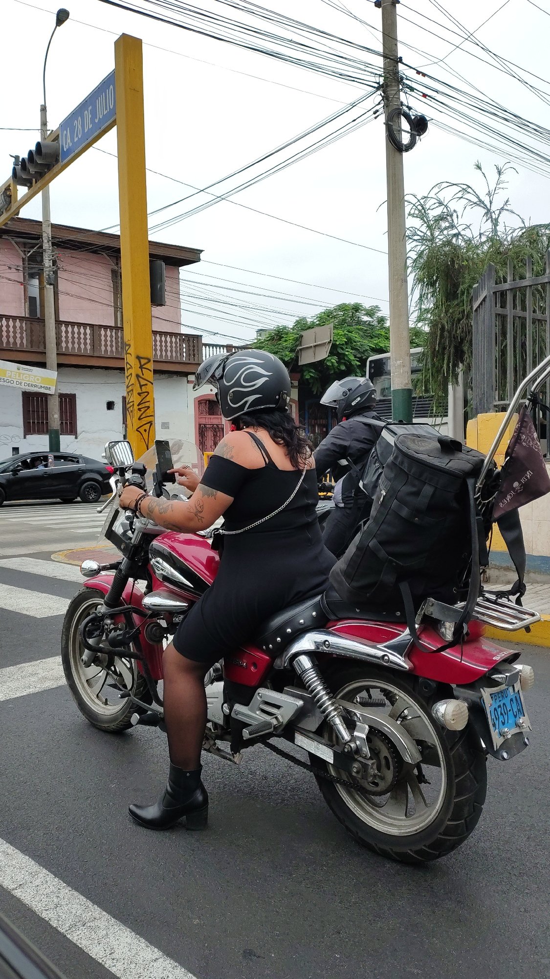 Woman on red motorcycle spotted at Barranco intersection