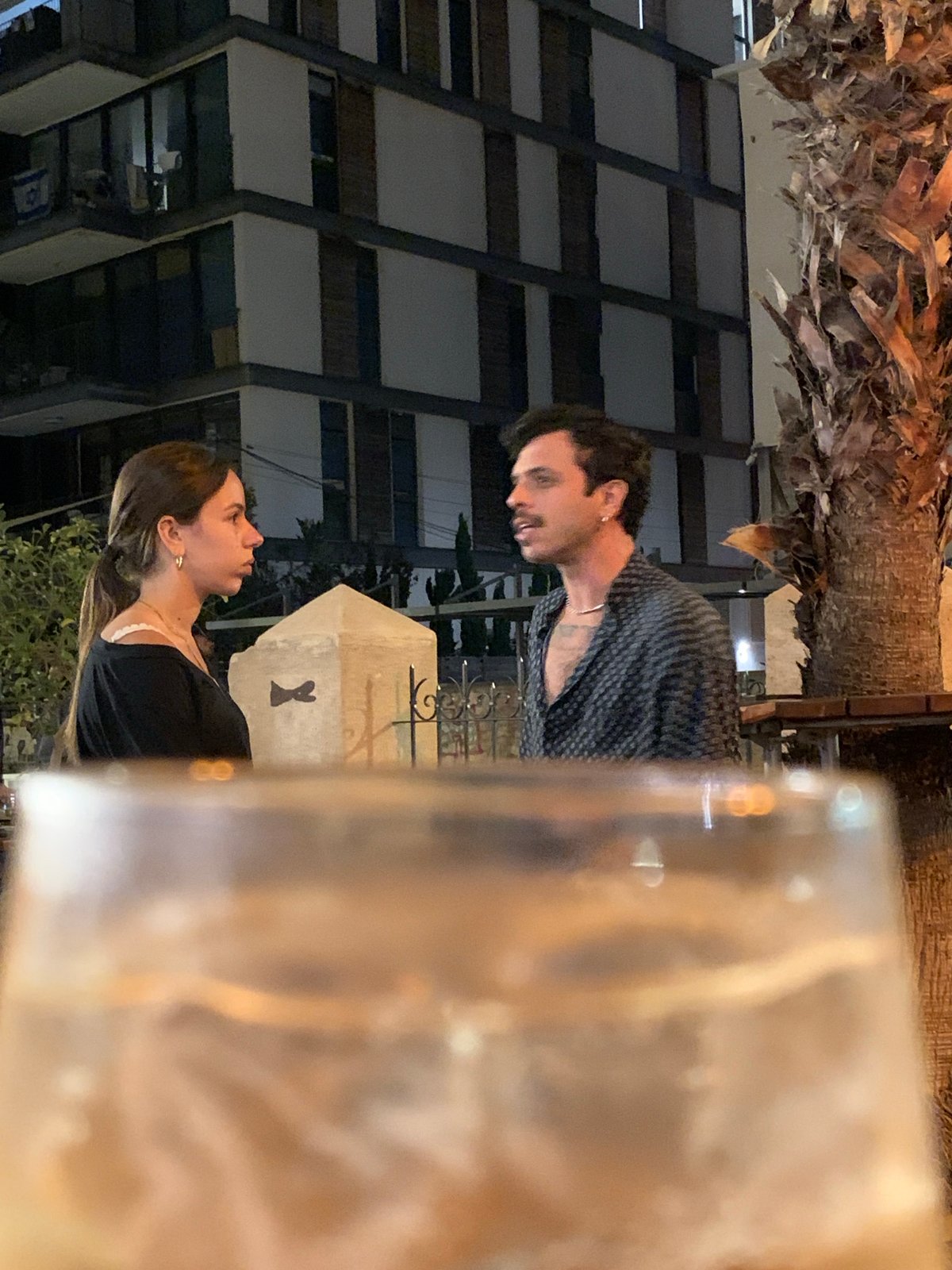 Nighttime conversation observed between couple in Tel-Aviv outdoor setting