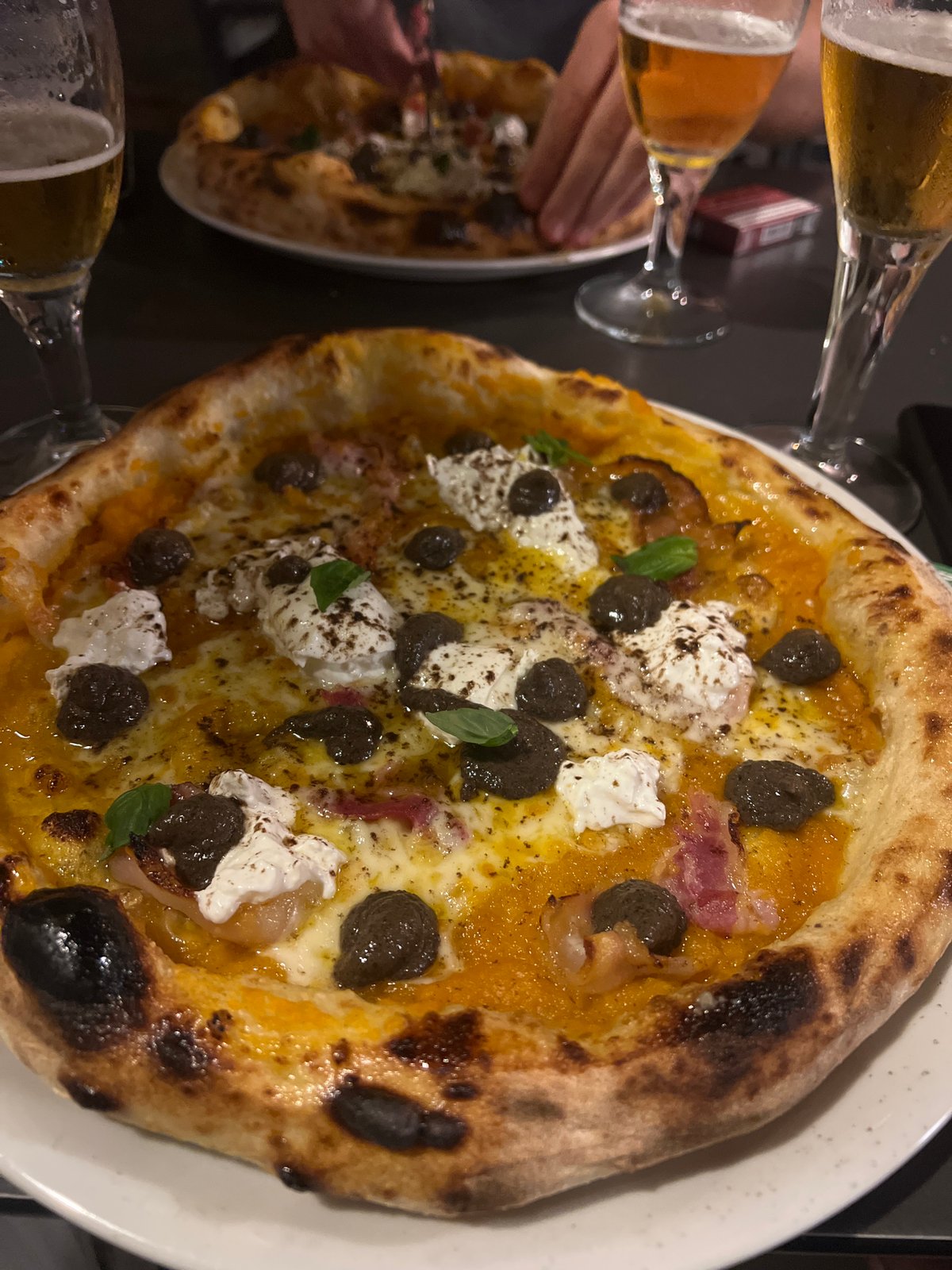 Burnt-crust pizza served with beer in València restaurant