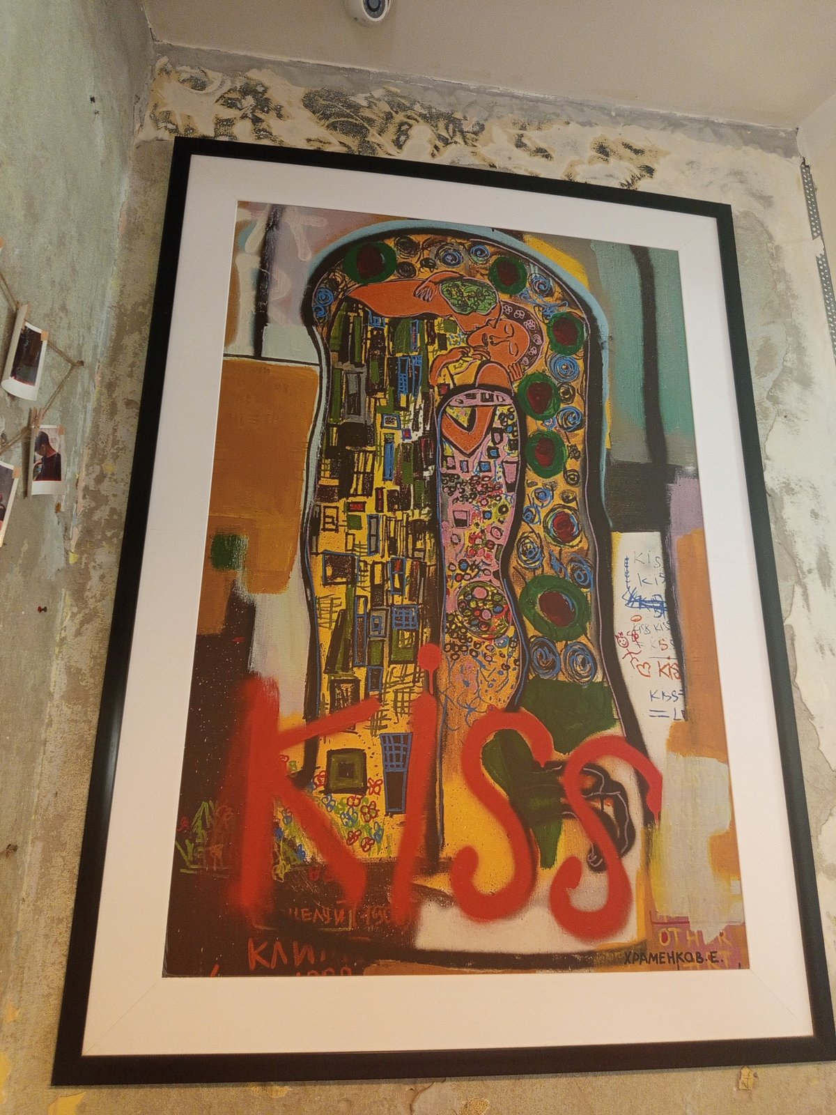 Framed abstract painting documented against partially painted indoor wall