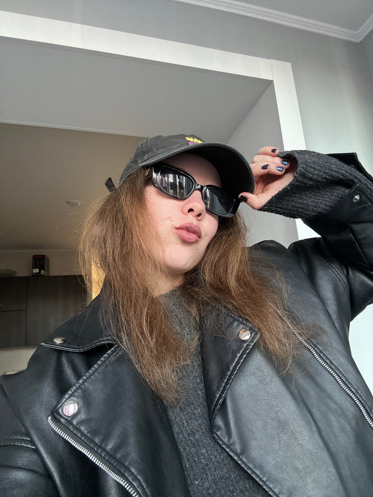 Woman takes selfies in black outfit in Krasnoyarsk apartment