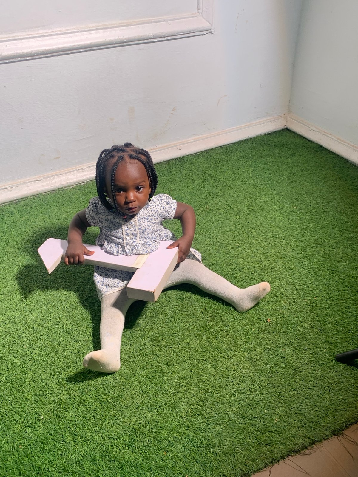 Child plays with numbers indoors while soccer games unfold outdoors