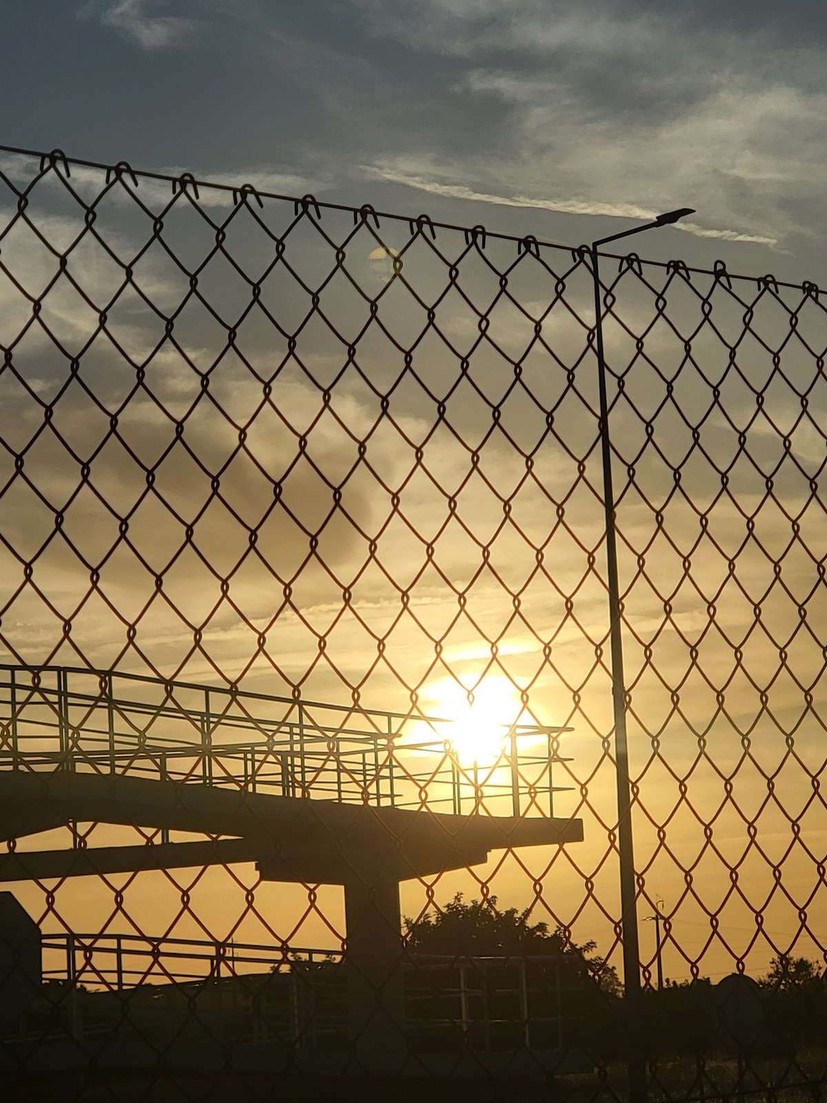 Sunset through a chain-link fence near Faro, Portugal