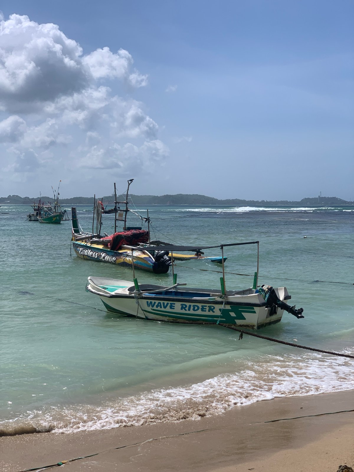 Colorful fishing boats line the shores of Weligama Beach