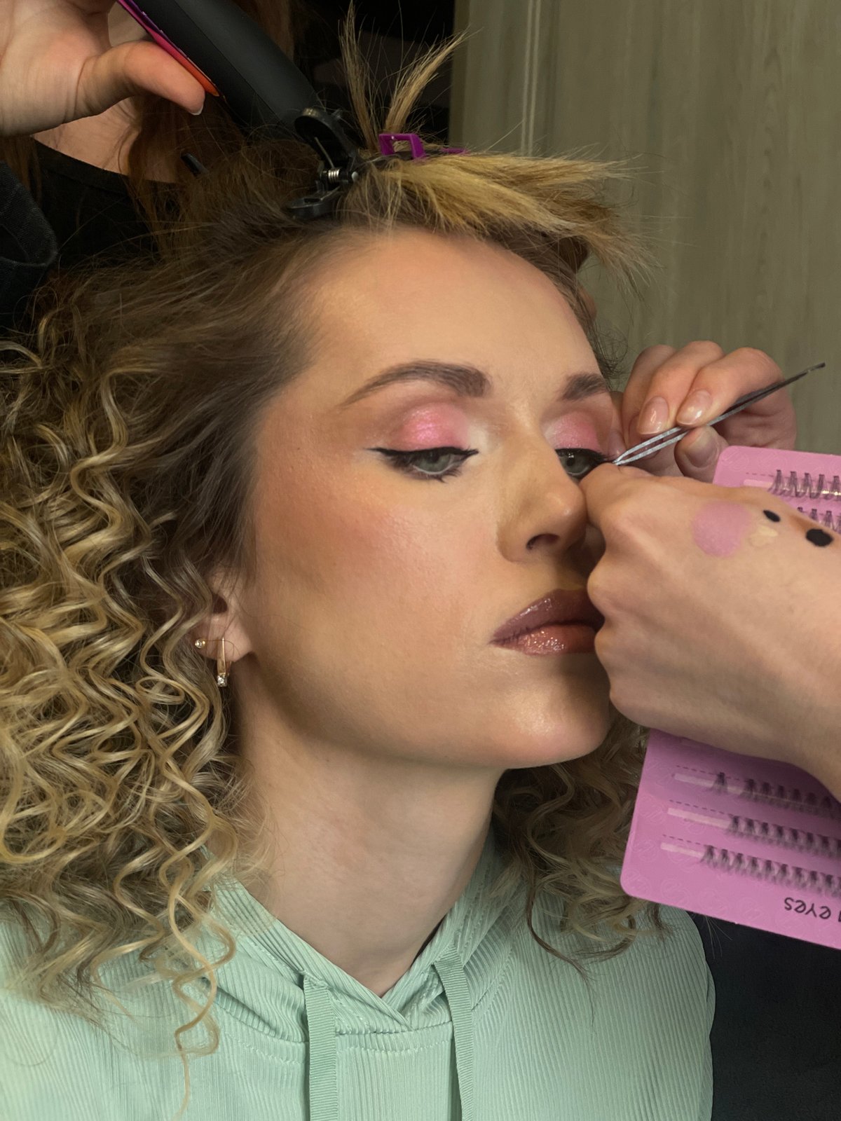 Woman receives beauty treatments including false eyelashes