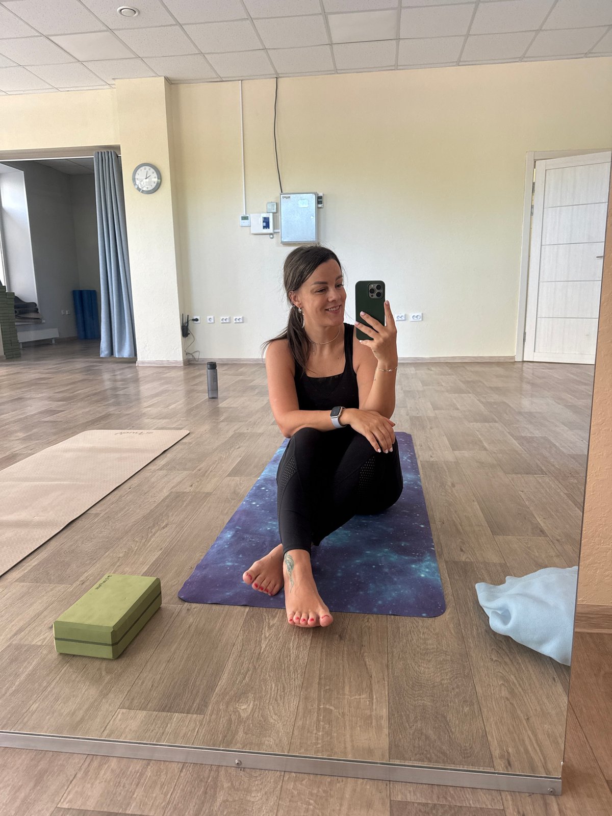 Woman takes mirror selfie during yoga session in Krasnoyarsk studio