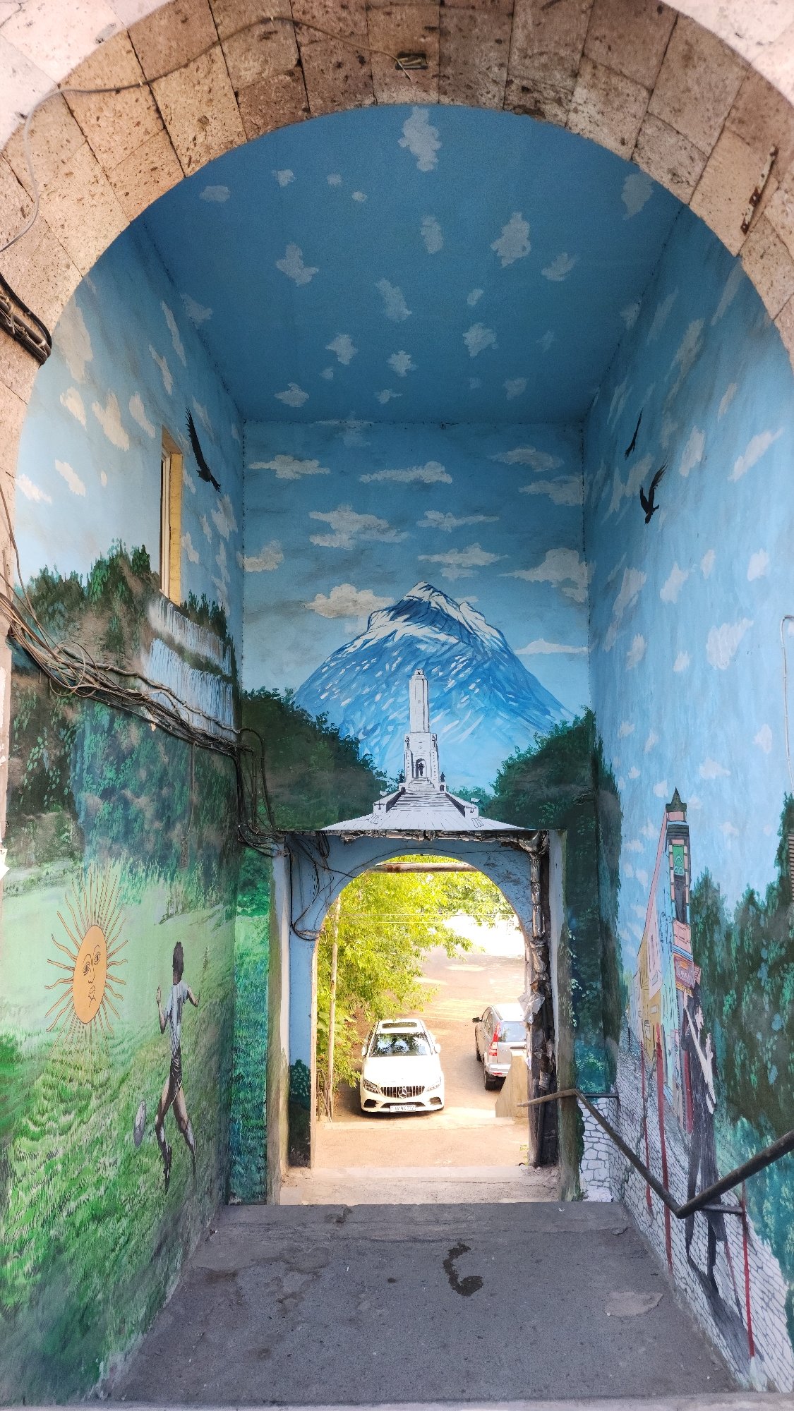 Street-level Yerevan: murals, stone architecture, and a sleeping dog