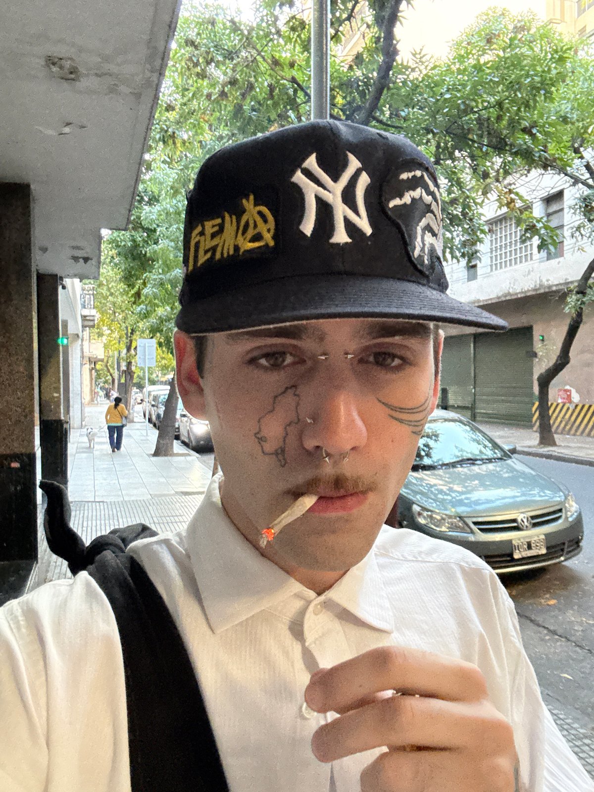 Tattooed youth spotted smoking in Buenos Aires wearing Yankees cap