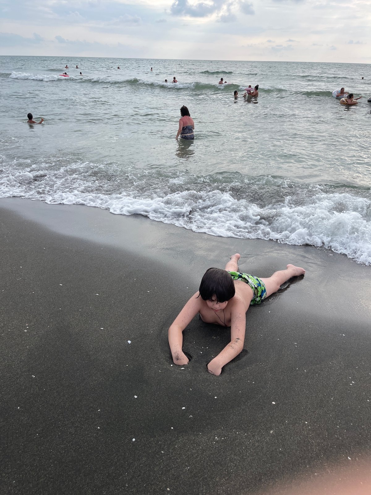 Crowded summer afternoon on Ureki's black sand beach