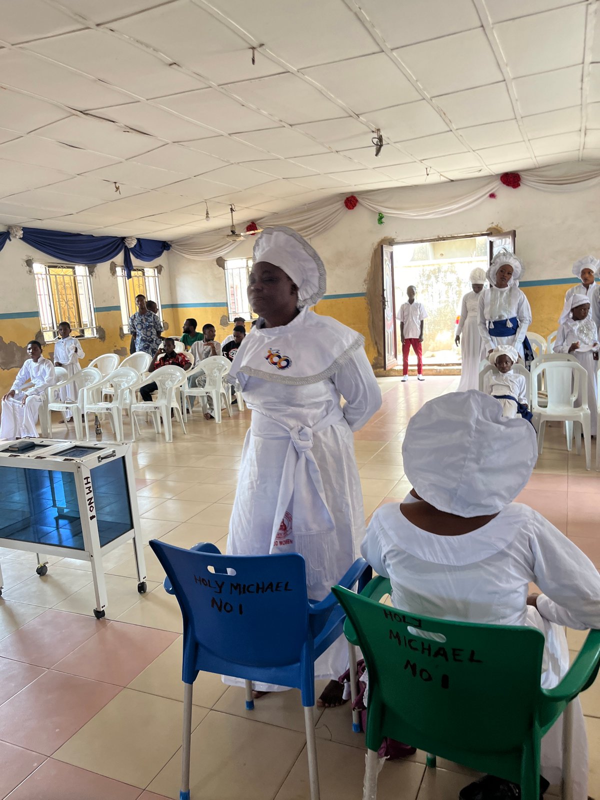 White-robed congregation sings and plays music at a religious gathering