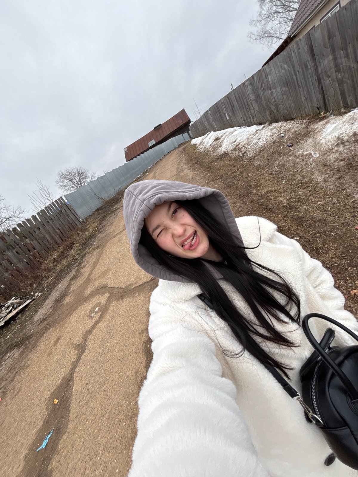 Woman takes playful selfies in wooden attic space