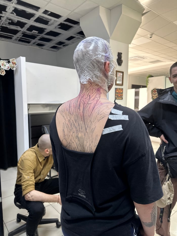 Client receives back tattoo with plastic-wrapped head in Rostov studio