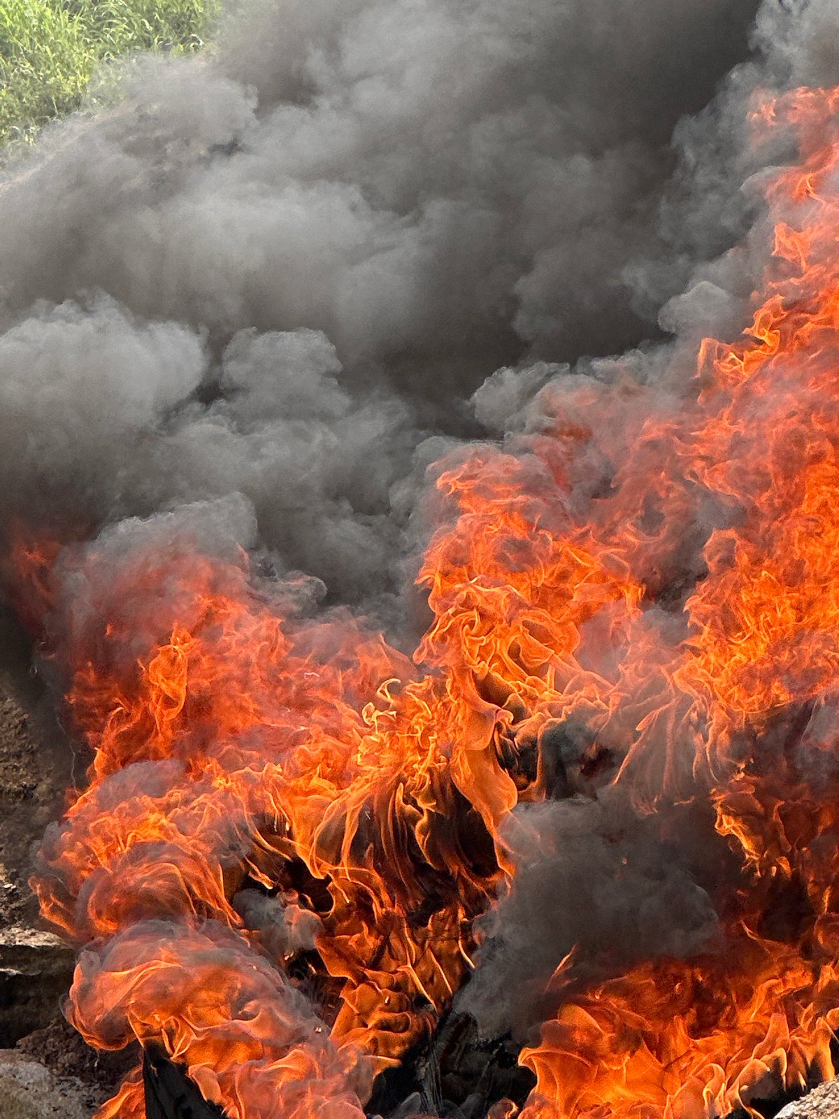 Tire fire burns on rocky slope in Gura Top, Nigeria