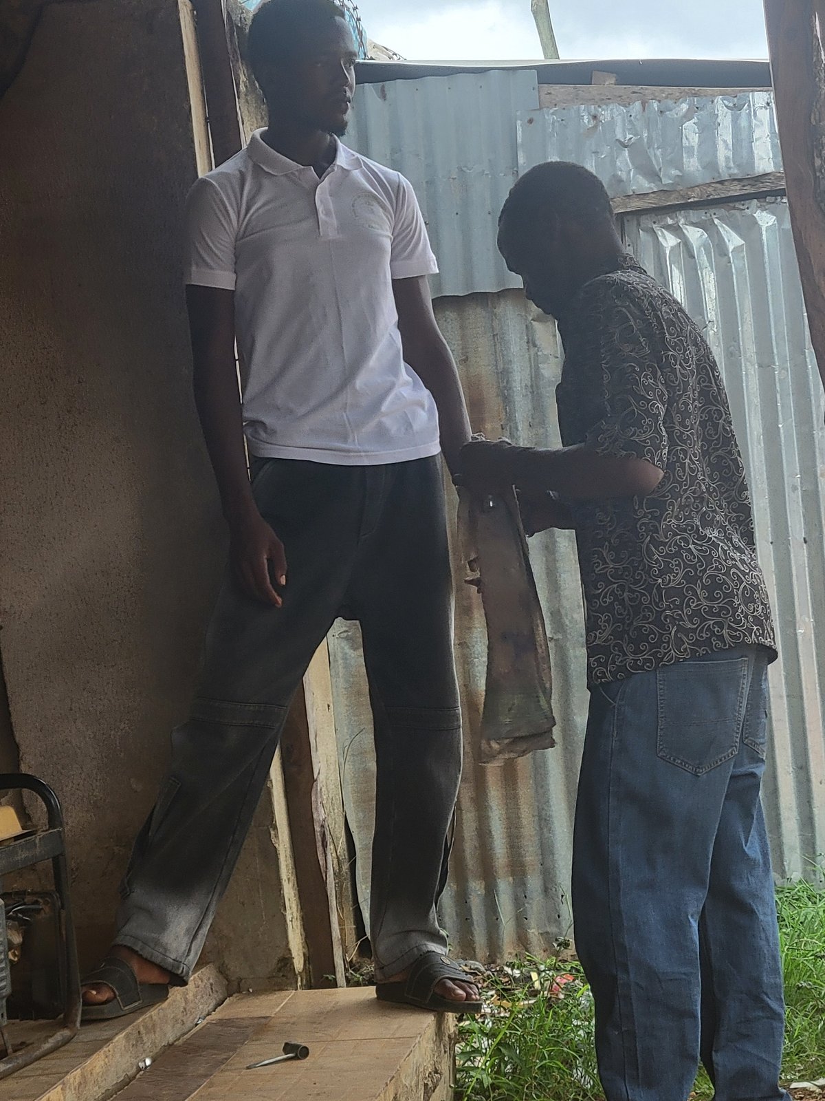 Two men meet at outdoor workshop in Keffi, Nigeria