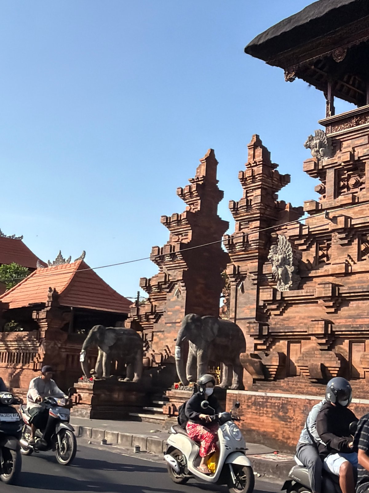 Balinese temple gate with elephant statues on a Denpasar street