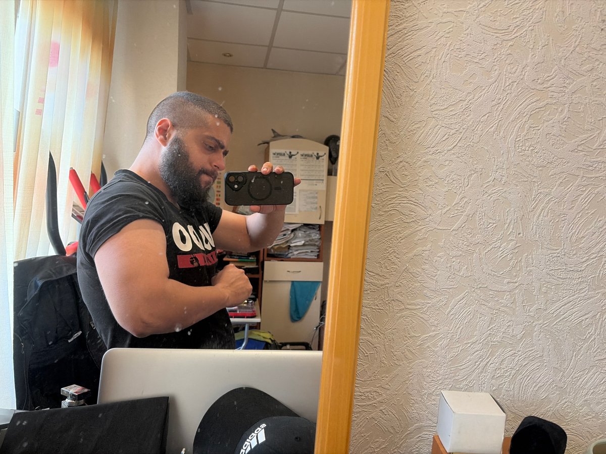 Bearded man documented in mirror selfie and wall portrait