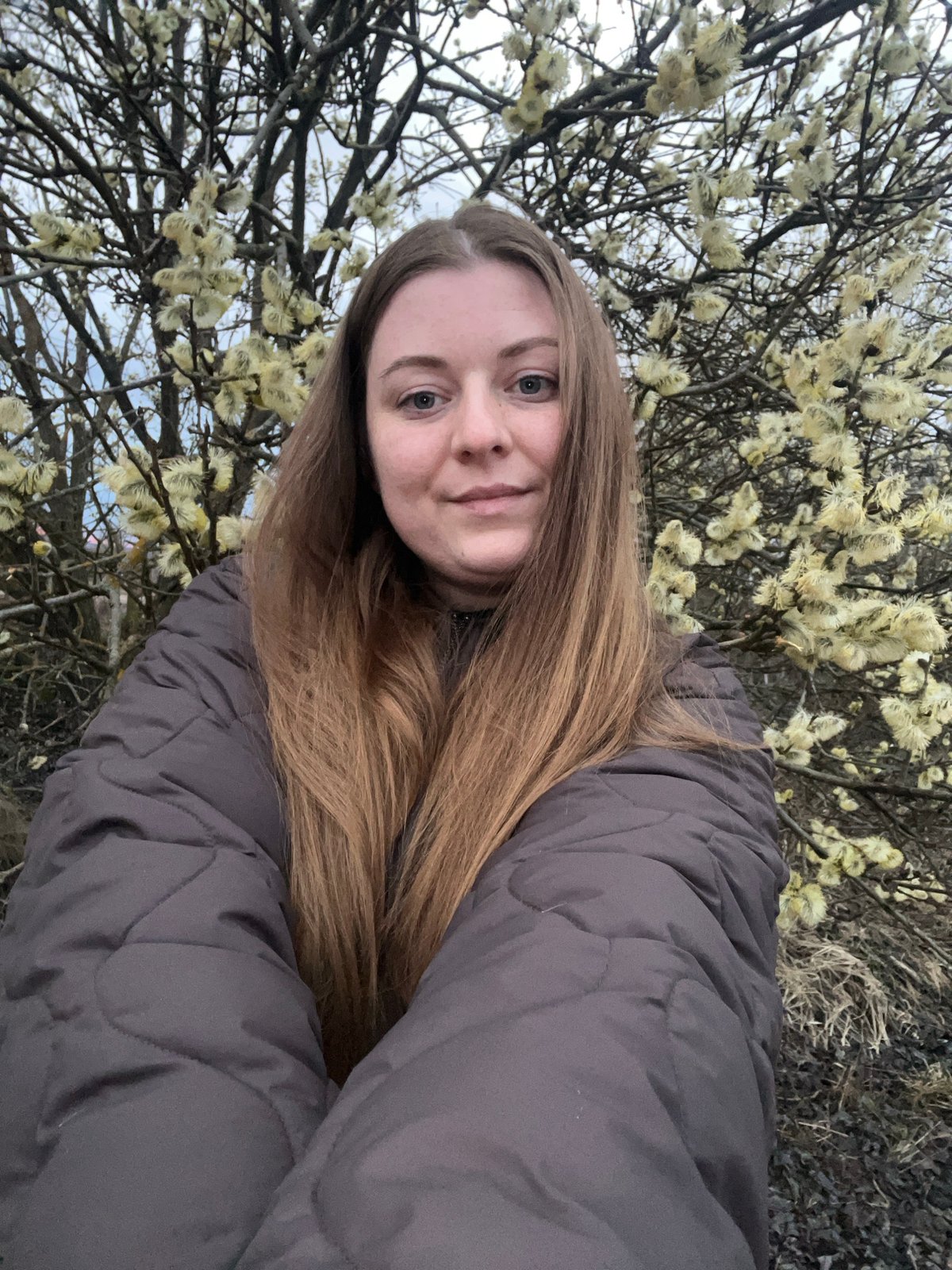 Woman takes spring selfies with blooming willows in Russia