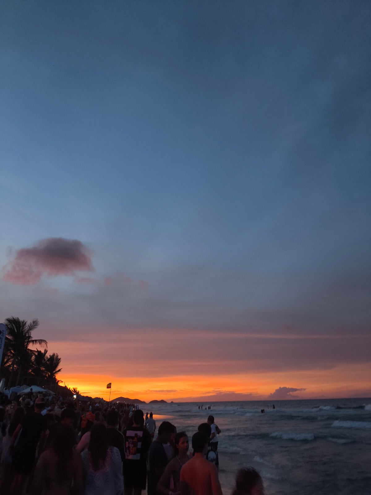 Evening crowds gather at Playa Parguito beach during sunset