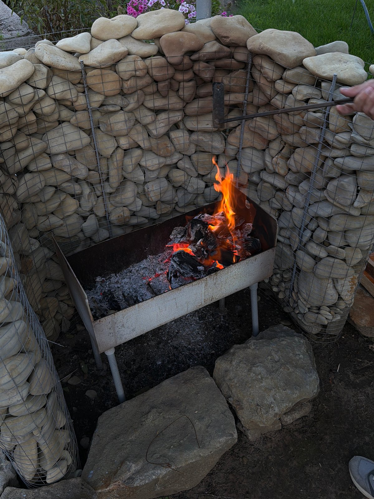 Backyard barbecue in Kamyshin, Russia, with gabion walls and grilling meat