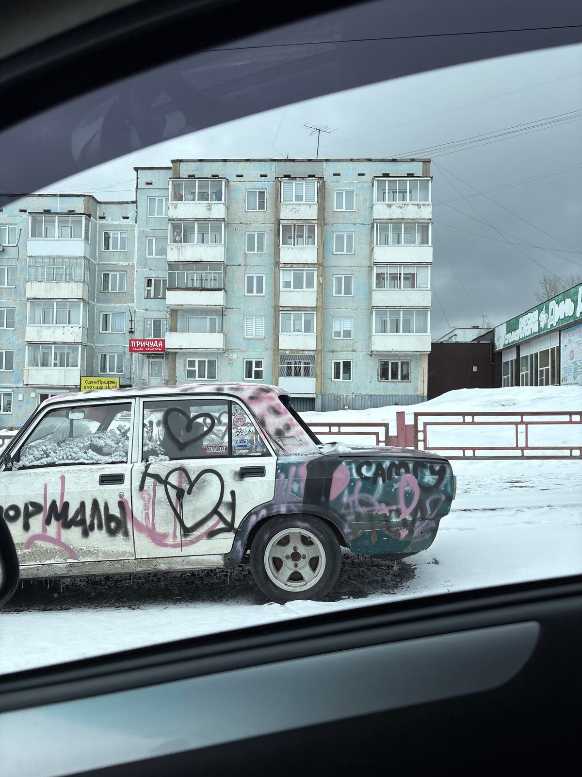 Graffiti-covered abandoned car spotted on snowy Ust-Ilimsk street