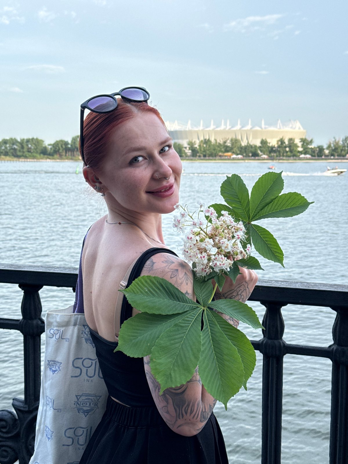 Woman poses with chestnut blossoms by Rostov-on-Don waterfront