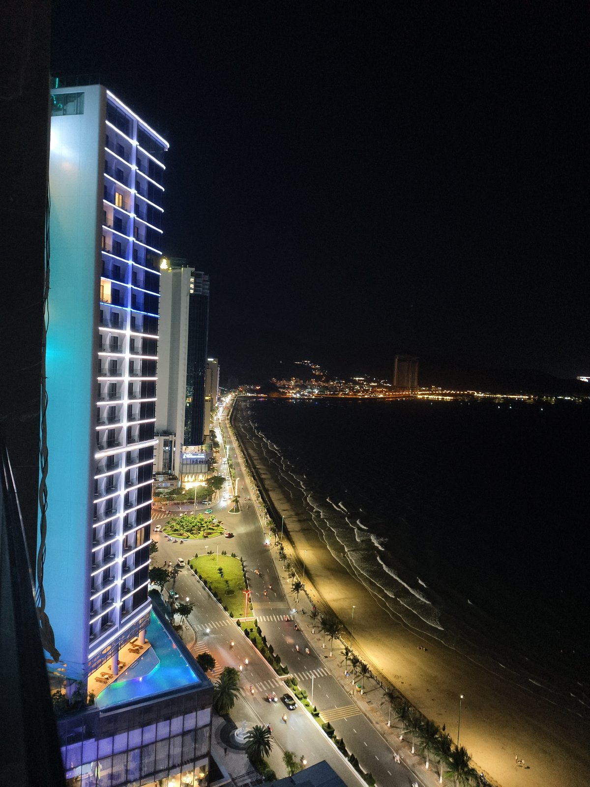 Nighttime beachside city skyline observed from elevated position