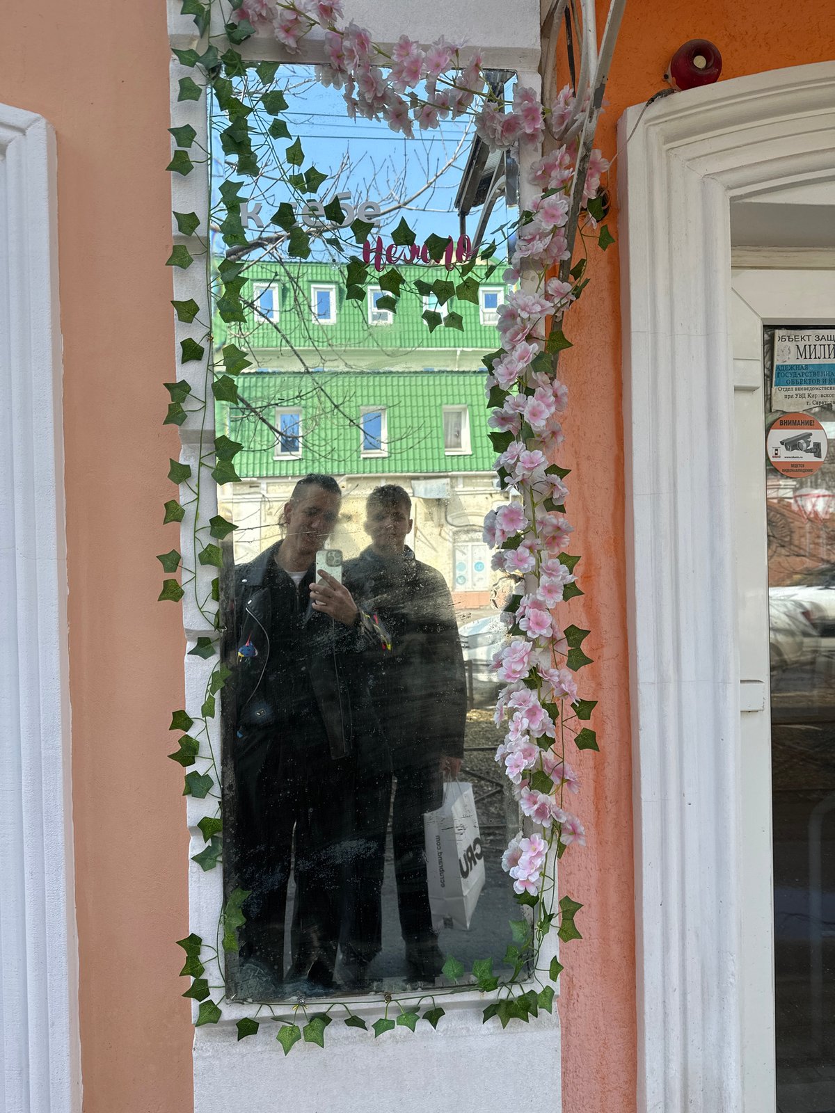 Window reflection captures smartphone photography moment in Saratov