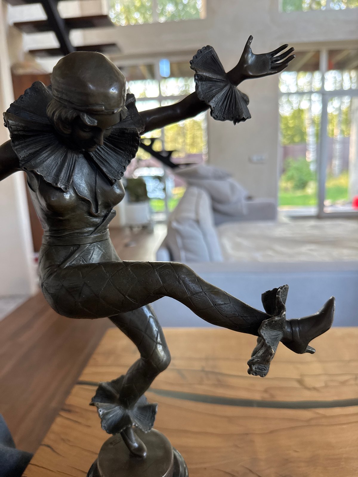 Three Siamese cats fed at home, bronze jester nearby