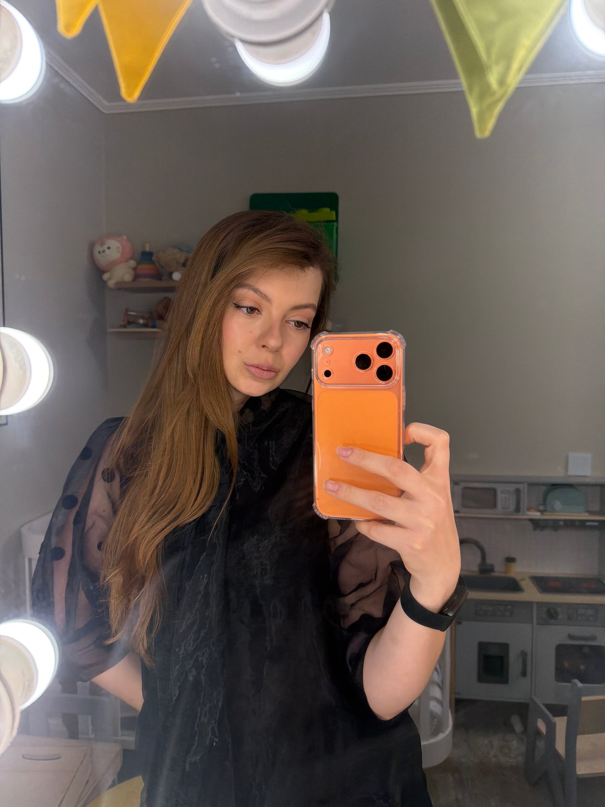 Woman Takes Selfie at Vanity Mirror with Orange Phone
