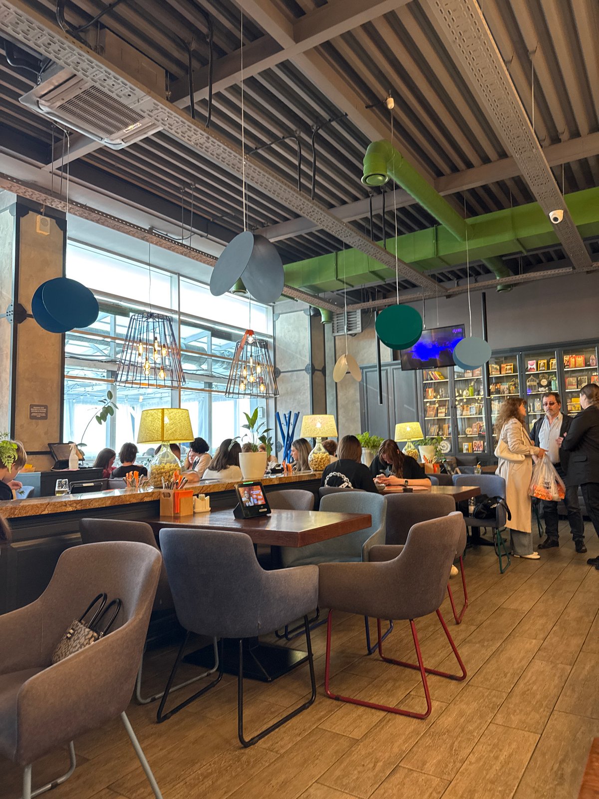 Afternoon diners gather at Saint Petersburg restaurant, woman reads Tokyo book