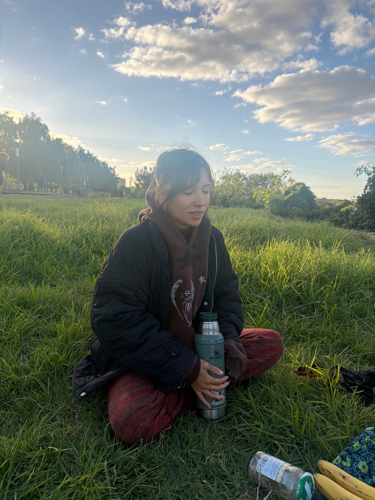 Person enjoys outdoor meal with thermos in Argentine field