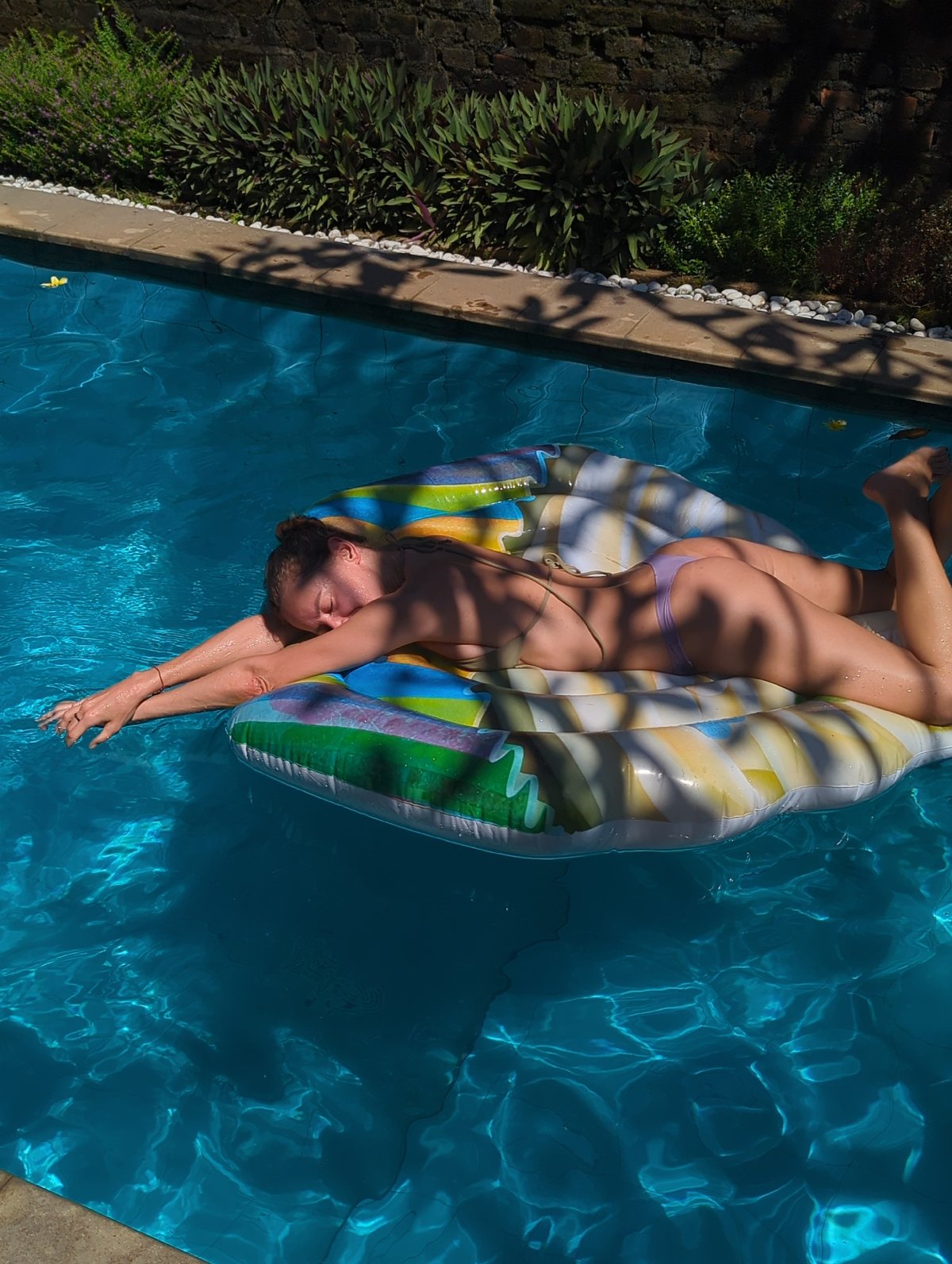 Woman relaxes on pool raft in North Kuta