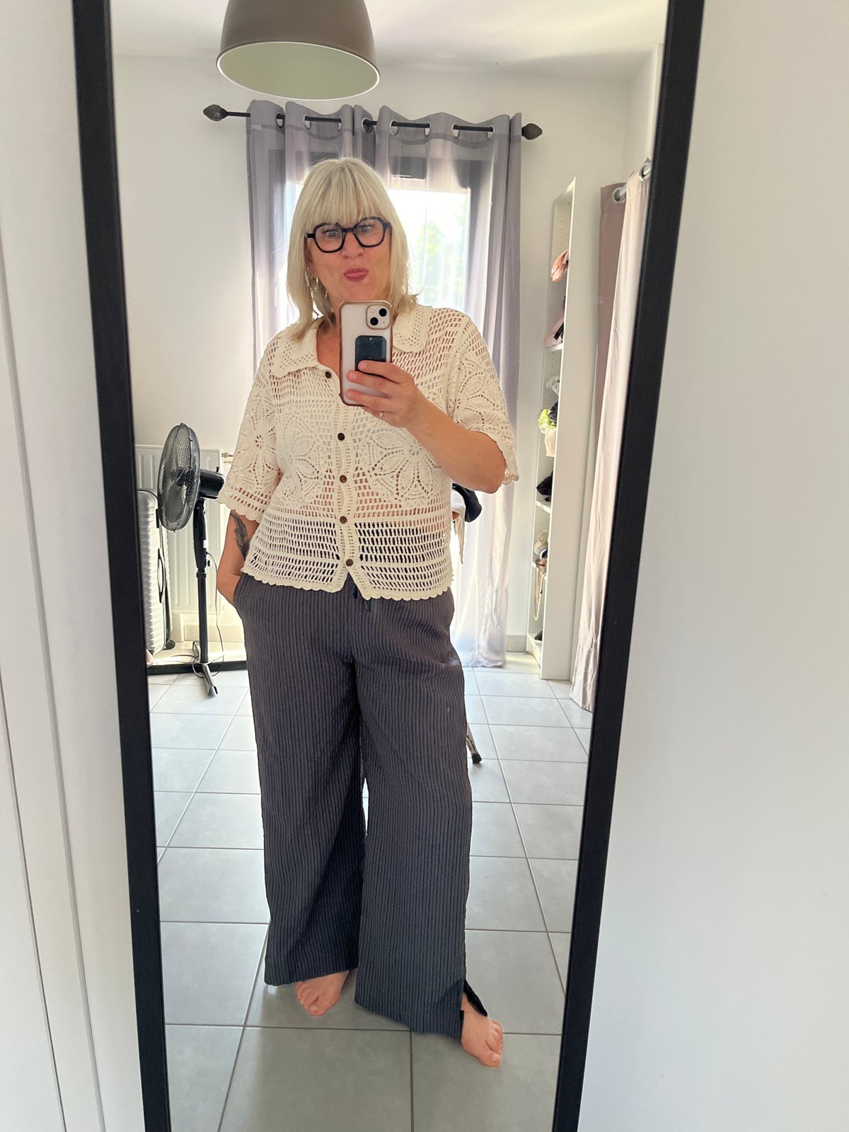 Person takes mirror selfie while trying on clothes in France