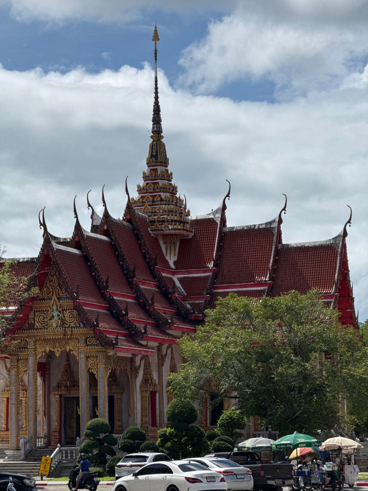 Exploring Wat Chalong temple grounds with a husky in tow