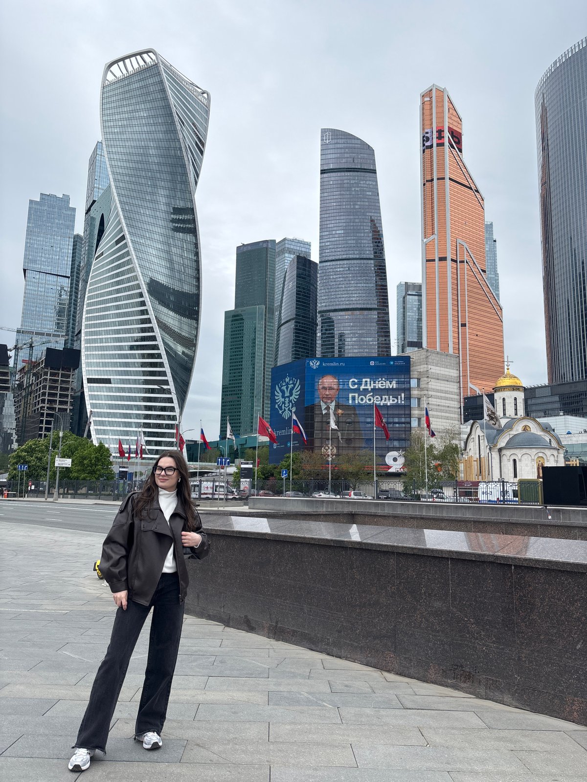 Woman photographs selfies at Moscow's business district skyline