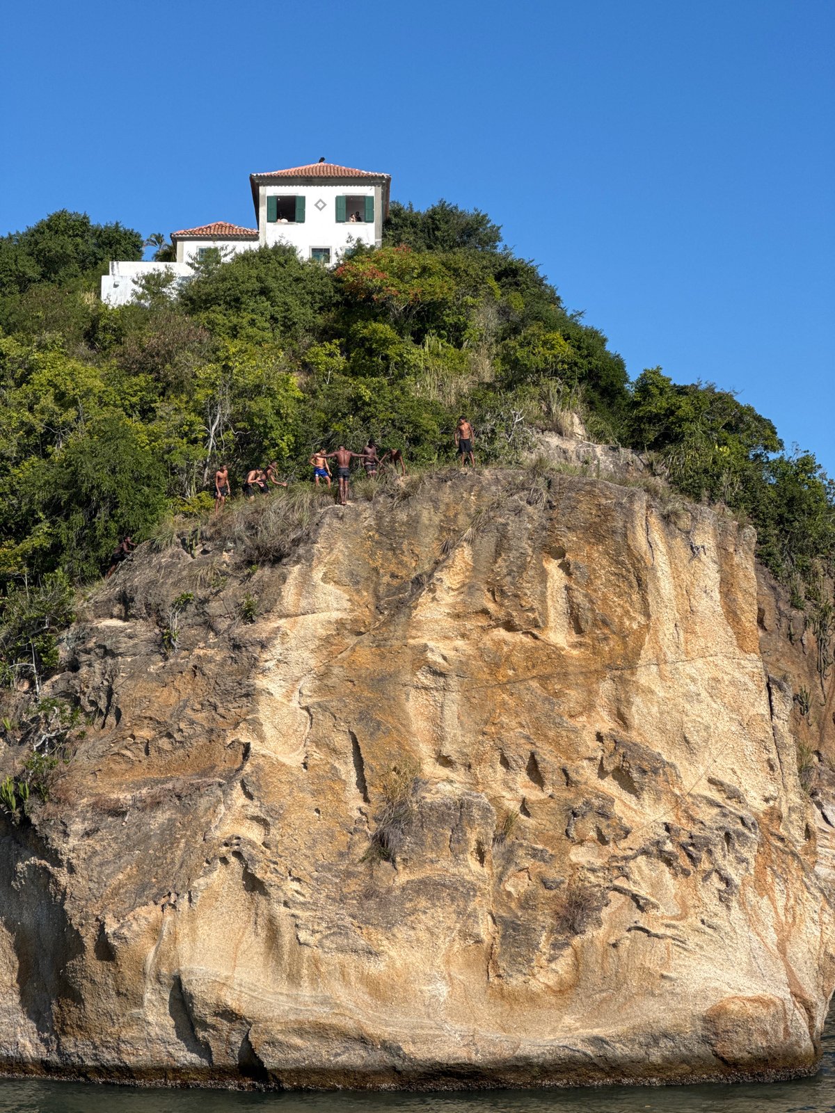 Cliff jumping off Niterói's rocky coastline