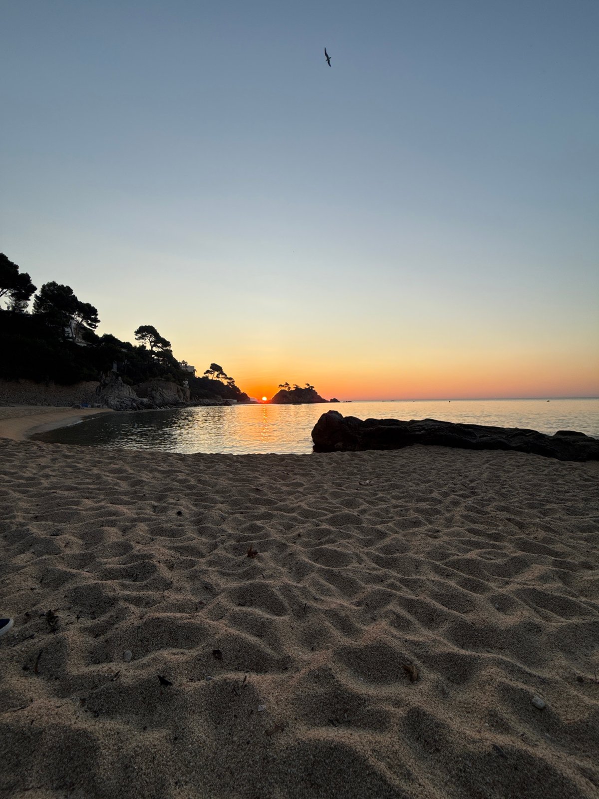 Sunrise over Platja d'Aro's calm Mediterranean shoreline