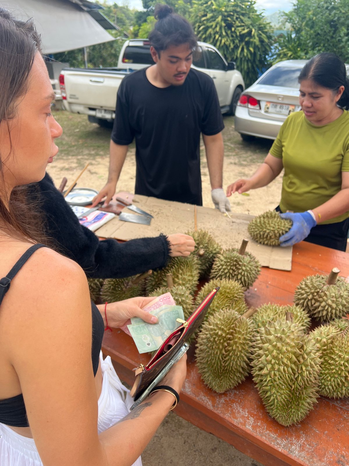 Roadside durian vendors serve customers in บ้านบางรักษ์, Thailand